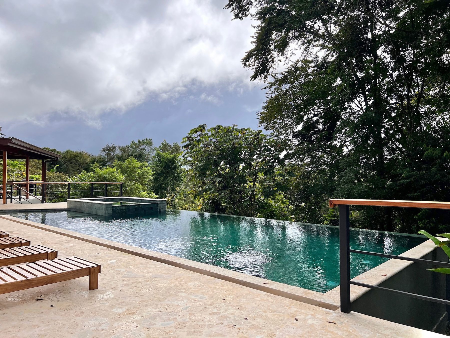 Teak loungers beside the infinity pool