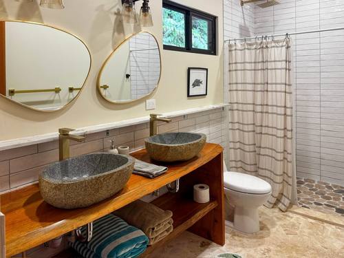 White-tile bath with twin stone vessel sinks