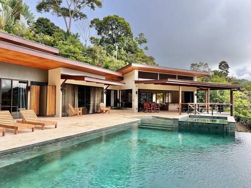 Infinity pool and villa framed by rainforest