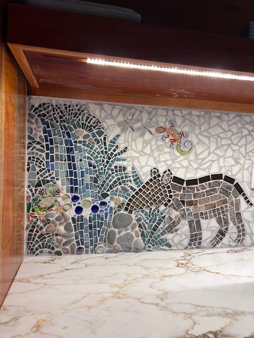 Mosaic waterfall scene with a cougar and gecko